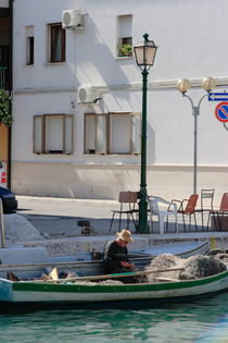 Fisherman mending nets in a boat by Intensivelight Panorama-Edition