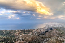 Fiery sun breaking through cloud over the coast by Nikos Vlasiadis