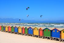 Kite surfer und bunte Badehäuser in Muizenburg am Boulders Beach von Mellieha Zacharias