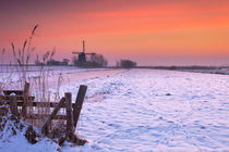Typical Dutch landscape with windmill in winter at sunrise von Sara Winter