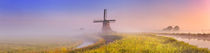 Traditional Dutch windmill at sunrise on a foggy morning von Sara Winter