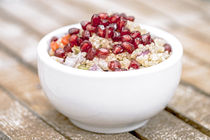 Quinoa Salat mit Granatapfelkernen, Radiccio, Gurke und Oliven auf hellbraunem Hintergrund by Dieter  Meyer