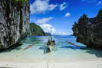 Outrigger boat on a little white beach and Clear water in th... by Danita Delimont