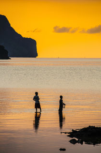 Silhouette of boys fishing at sunset in the bay of El Nido, ... by Danita Delimont
