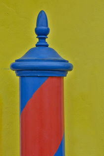 Red and blue painted and stripped pole with yellow home as b... by Danita Delimont