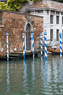 Gondola mooring posts in the canals of Venice by Danita Delimont