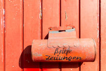 Red mailbox on a red wall by domi