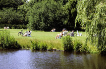 Menschen sitzen in einer Parkanlage und geniessen die Sommersonne. by fischbeck