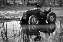 Toy tractor reflected in rain puddle black and white picture von Maud de Vries