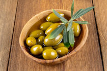 Grüne Oliven mit Zweig in einer Holzschale - Green olives with twig in a wooden bowl von Thomas Klee
