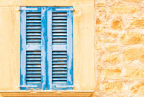 Mediterranean old blue wooden window shutters and rustic stone wall, detail view von Alex Winter