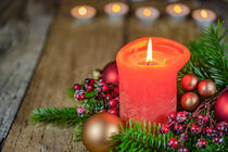 Burning red candle flame for Advent and Christmas with fir branches and baubles arrangement von Alex Winter