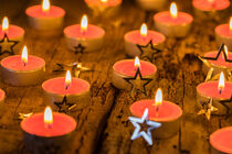 Traditional Advent and Christmas candles with silver star shapes decoration on wooden table von Alex Winter