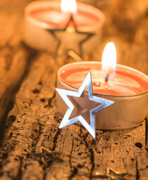 Burning xmas candles with christmas stars decoration by Alex Winter