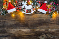 Christmas decoration with santa cap, reindeer, fir branches, red berries, pine cones and lights by Alex Winter