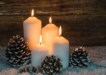 Christmas decoration with four white burning candles and pine cones von Alex Winter