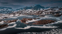 Snowy landscape of Hardangervidda with mountains and icy lakes in Norway von Bastian Linder