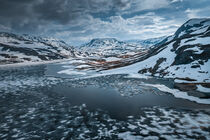 Snowy landscape of Hardangervidda with mountains and icy lakes in Norway von Bastian Linder