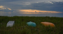 Bunte Ruderboote liegen im Gras am dänischen Ostseestrand. by Jürgen Kottmann