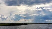 Sonnenstrahlen durchbrechen die dichten Gewitterwolken über Botswana von Dieter Stahl