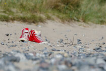 Rote Schuhe im Sand von René Lang