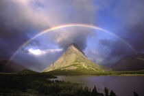 Full rainbow and stormy sky over Grinnell Point and Swift Current Lake , Montana by Danita Delimont