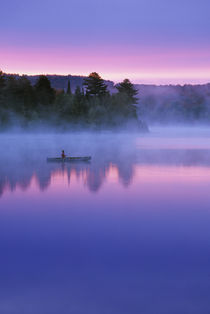 Canada, Ontario, Algonguin Park, Canoeist on lake at sunrise.   Credit as by Danita Delimont