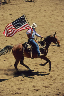 USA flag at rodeo opening ceremony (NO MODEL RELEASE) by Danita Delimont