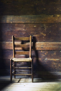 Ladderback chair in empty room by Panoramic Images