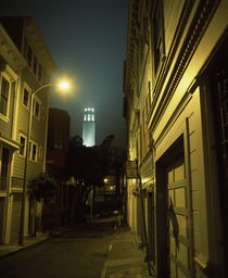 Buildings along a street with a tower in the background by Panoramic Images