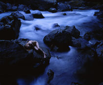 High angle view of a teenage girl lying naked on a rock von Panoramic Images