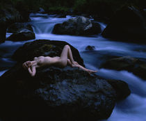 High angle view of a teenage girl lying naked on a rock by Panoramic Images