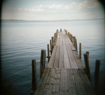 Person sitting on a pier, Lake Bolsena, Italy von Panoramic Images