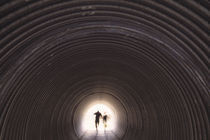 People hiking through underpass, Scotland. by Panoramic Images
