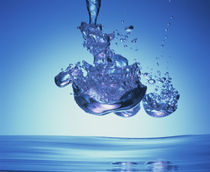 Iridescent water bubble formation floating above the surface of deep blue water von Panoramic Images