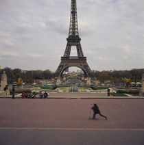 Side profile of a boy riding a push scooter, Eiffel Tower, Paris, France by Panoramic Images