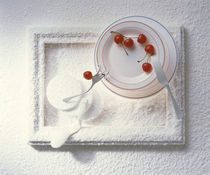 Cherries on staked plates resting on tray made of white sand by Panoramic Images