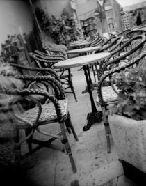 Empty chairs and tables in a sidewalk cafe by Panoramic Images
