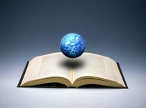 Small cloud filled globe hovering above open book von Panoramic Images