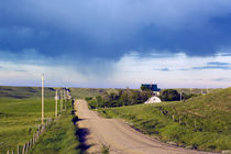 Dirt road through hilly farmland, distant storm, Missouri Breaks, Montana, USA. von Panoramic Images