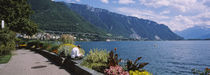 Rear view of a man sitting at the lakeside, Lake Geneva, Montreux, Switzerland by Panoramic Images