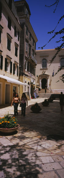 Two women walking in front of a courtyard in Corfu Old Town, Corfu, Greece von Panoramic Images