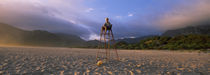 Boy sitting on a life guard on the beach, Kleinmond, Eastern Cape, South Africa by Panoramic Images