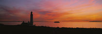 Silhouette of a lighthouse at sunset, Scotland by Panoramic Images