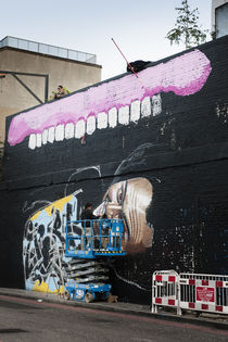 Two Graffiti Artists decorating a wall. by Tom Hanslien
