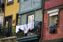 Woman hanging laundry from window in the historic riverside Ribeira district von Danita Delimont