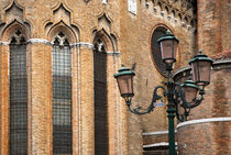 Italy - A lamp post is standing outside an old brick church by Danita Delimont