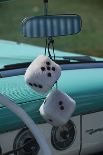 Fuzzy dice in a 1950s-era convertible by Danita Delimont