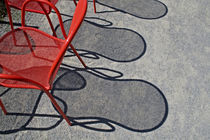 Red wire chairs shadows on concrete by Danita Delimont