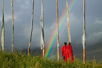 Rainbow over two monks with praying flags in the Phobjikha Valley (MR) by Danita Delimont